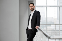 Businessportrait einer Führungsperson in Empfangshalle vor urbanem Hintergrund