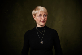 Mitarbeiterportrait einer Angestellten Optikerin vor edlem Hintergrund.