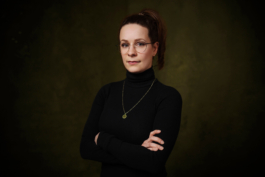 Mitarbeiterportrait einer Angestellten Optikerin vor edlem Hintergrund.