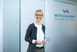 Mitarbeiterportrait einer Angestellten in einem gläsernen Besprechungsraum.