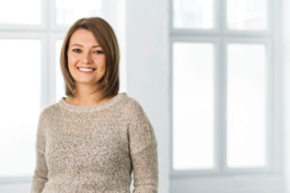 Mitarbeitertestimonial einer Angestellten in heller, freundlicher Umgebung.