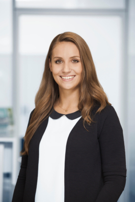 Mitarbeiterportrait einer Marketingexpertin vor hellem Bürohintergrund