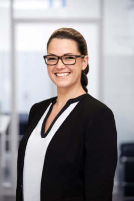 Businessportrait einer Angestellten im Bereich Human Resources vor hellem Bürohintergrund.