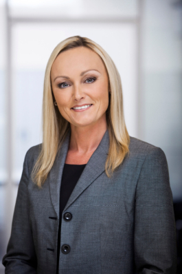 Businessportrait einer Angestellten im Bereich Human Resources vor hellem Bürohintergrund.