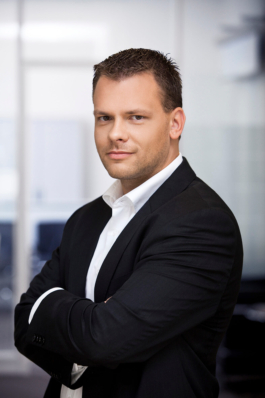 Businessportrait eines Angestellten im Bereich Human Resources vor hellem Bürohintergrund.