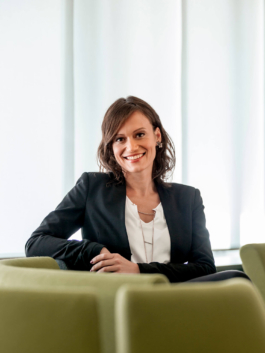 Mitarbeiterportrait für den Nachhaltigkeitsbericht des Spar und Bauverein Dortmund eG. Mitarbeiterin sitzt in modernem Empfangsbereich.