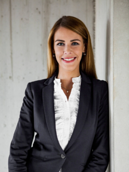 Businessportrait für den Geschäfstbericht des Spar und Bauverein Dortmund eG. Mitarbeiterin lehnt an Betonmauer auf einer Baustelle.