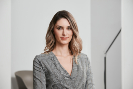 Mitarbeiterportrait einer leitenden Angestellten in moderner Büroumgebung.