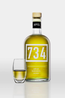 Werbefotografie einer Spirituosenflasche der Marke 734 vor hellgrauem Hintergrund. Neben der Flasche steht ein befülltes Likörglas.